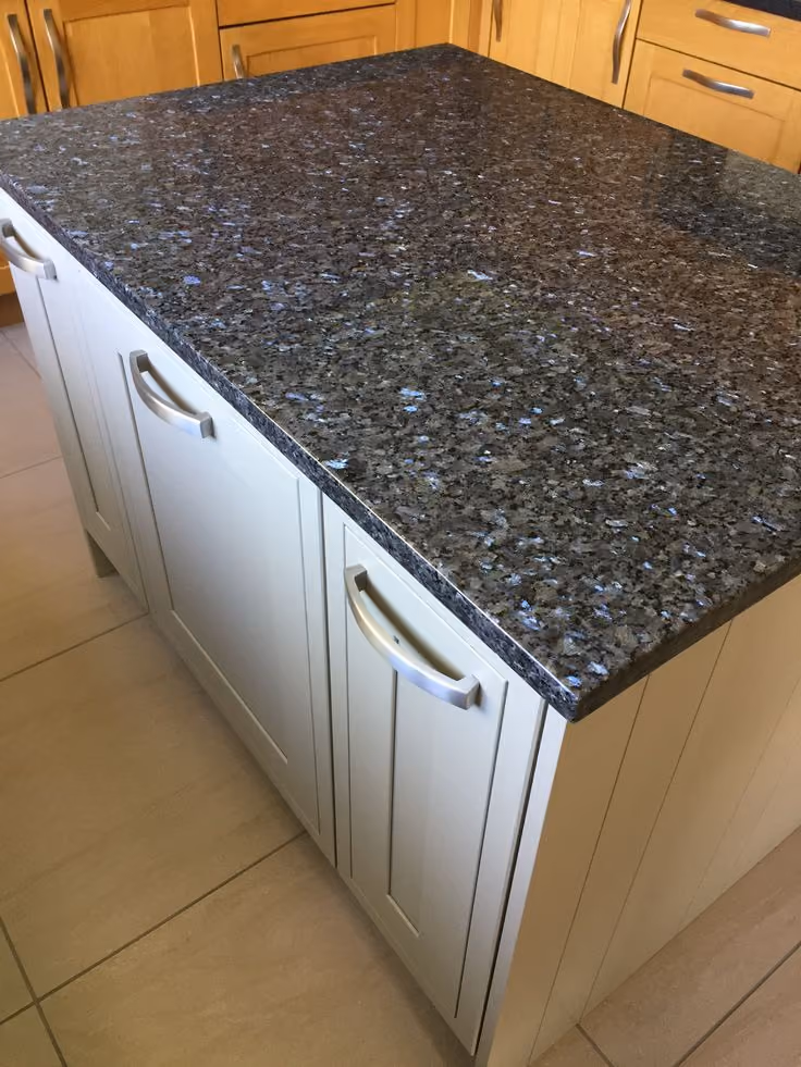 This may contain: an image of a kitchen setting with granite counter tops and cabinets in the backround