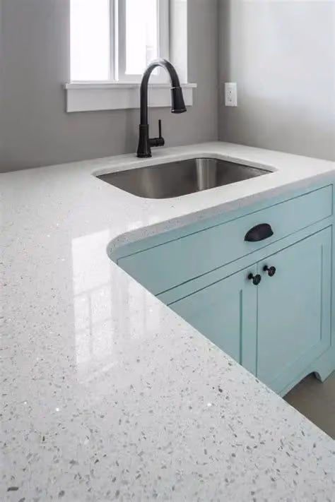 This may contain: a kitchen with white counter tops and blue cabinets