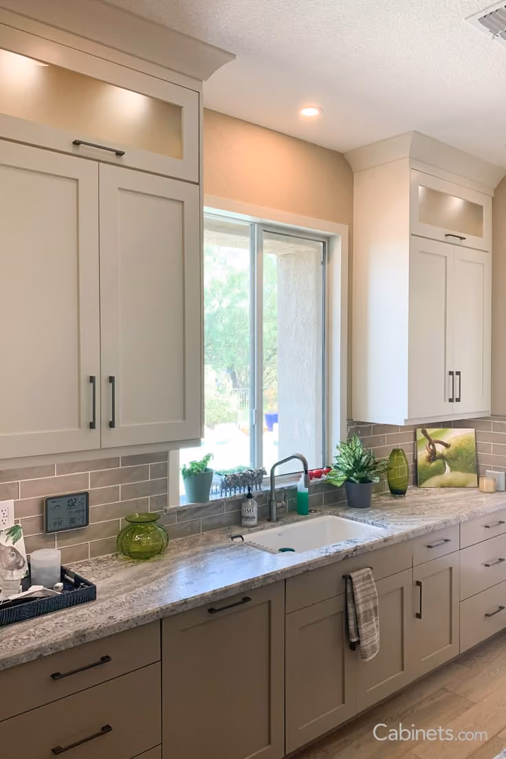 This may contain: a kitchen with white cabinets and granite counter tops, along with an open window to the outside