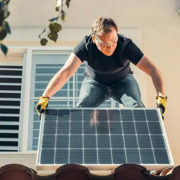 man moving solar panels