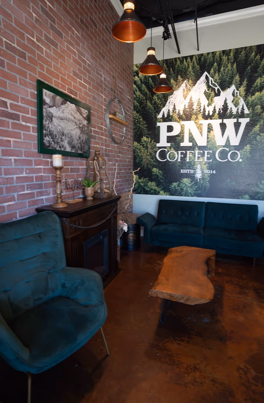 A coffee shop with a brick wall and a green couch.