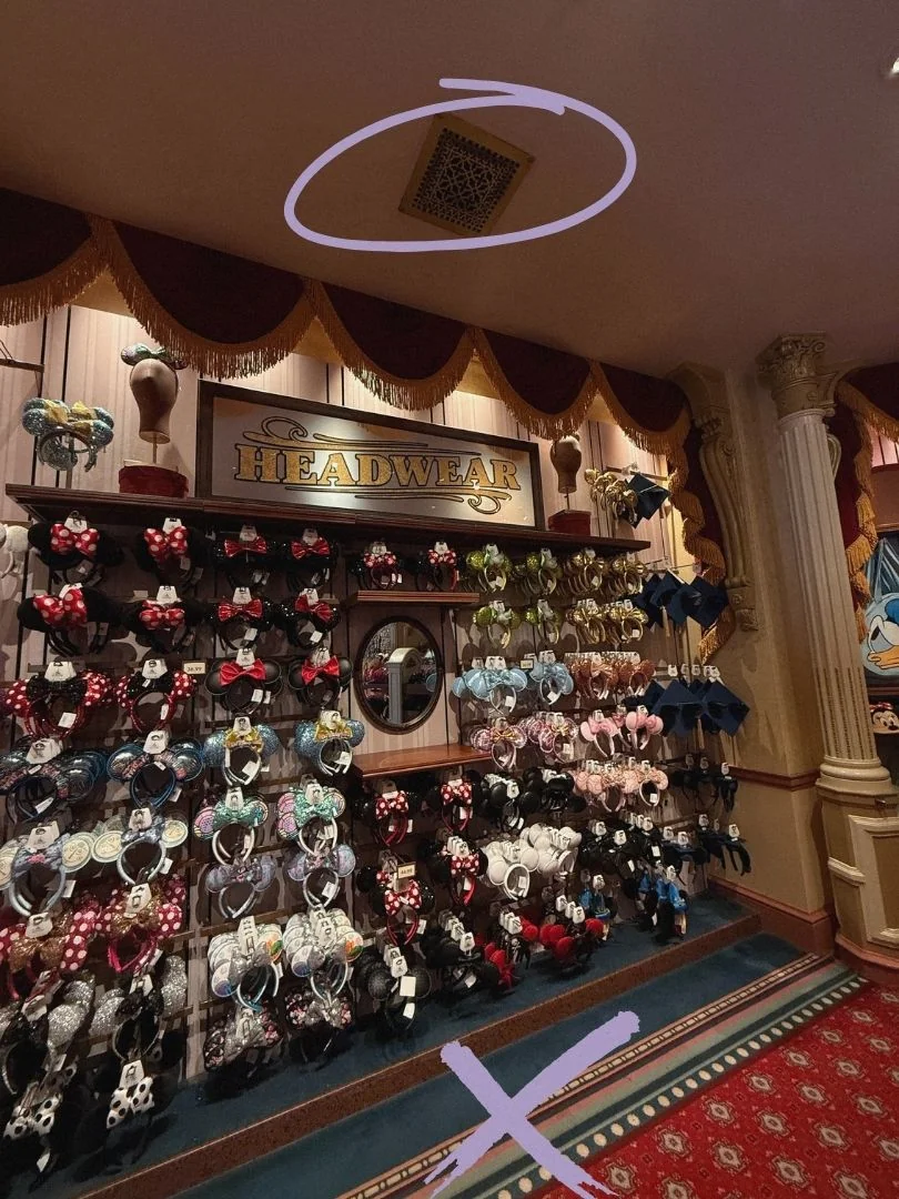 Emporium headwear wall stocked with Minnie and Mickey ear headbands beneath a gold "Headwear" sign.