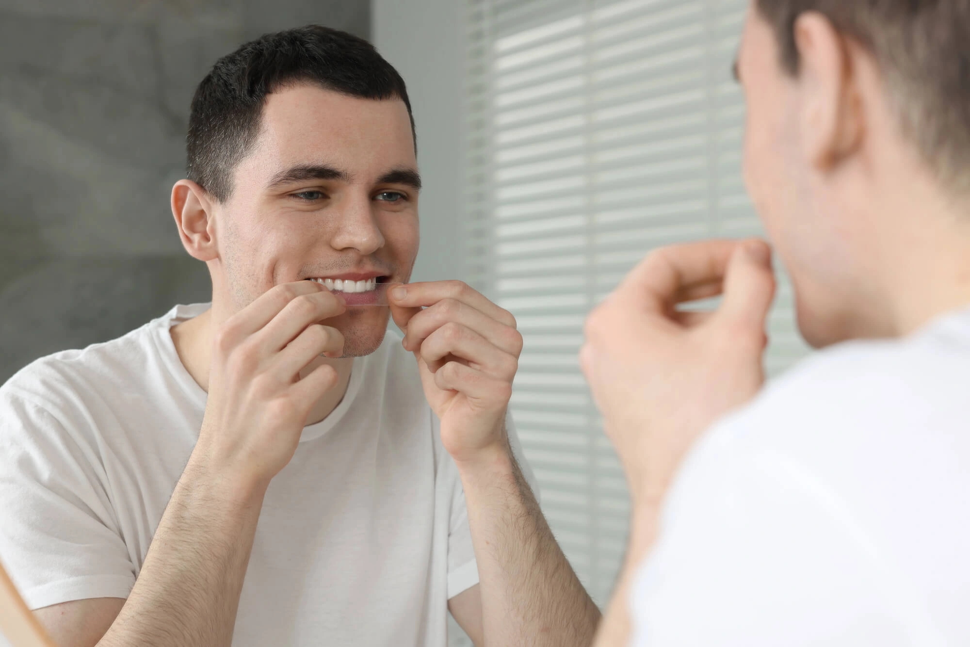 man using stripes for teeth whitening Philadelphia