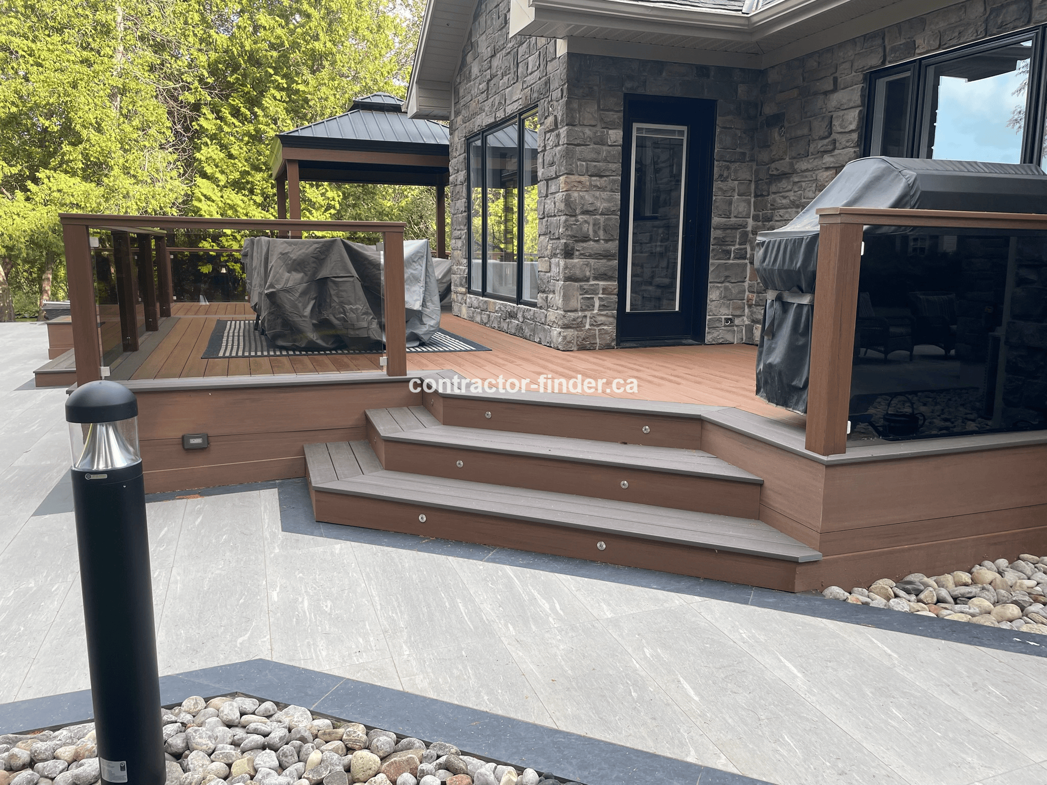 Modern deck installation in Collingwood with glass railing, built-in LED lights and patio gazebo