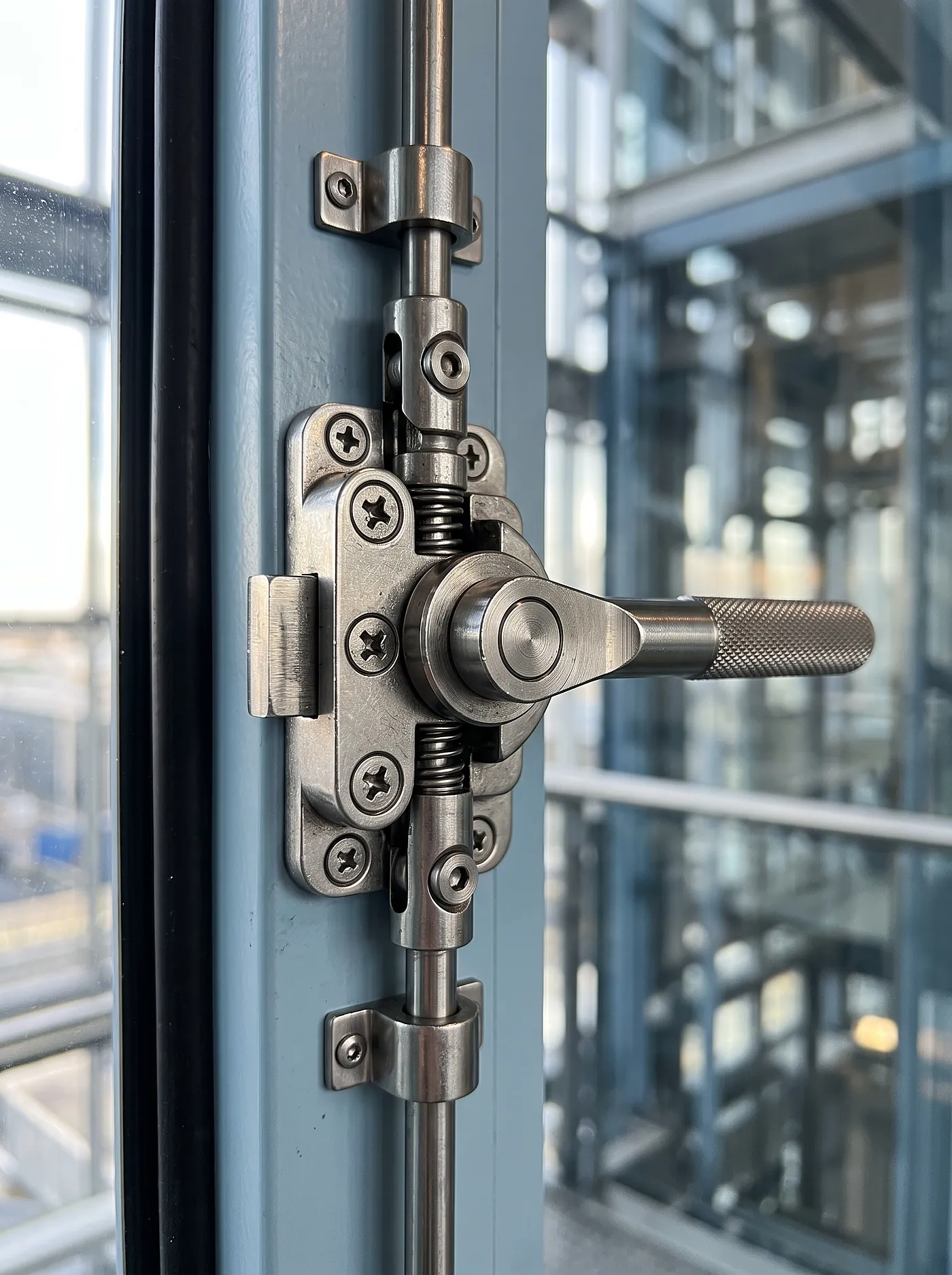 Precision multi-point security lock mechanism on a glass door, tamper-resistant containment hardware.