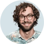 A man with glasses and a beard smiling.