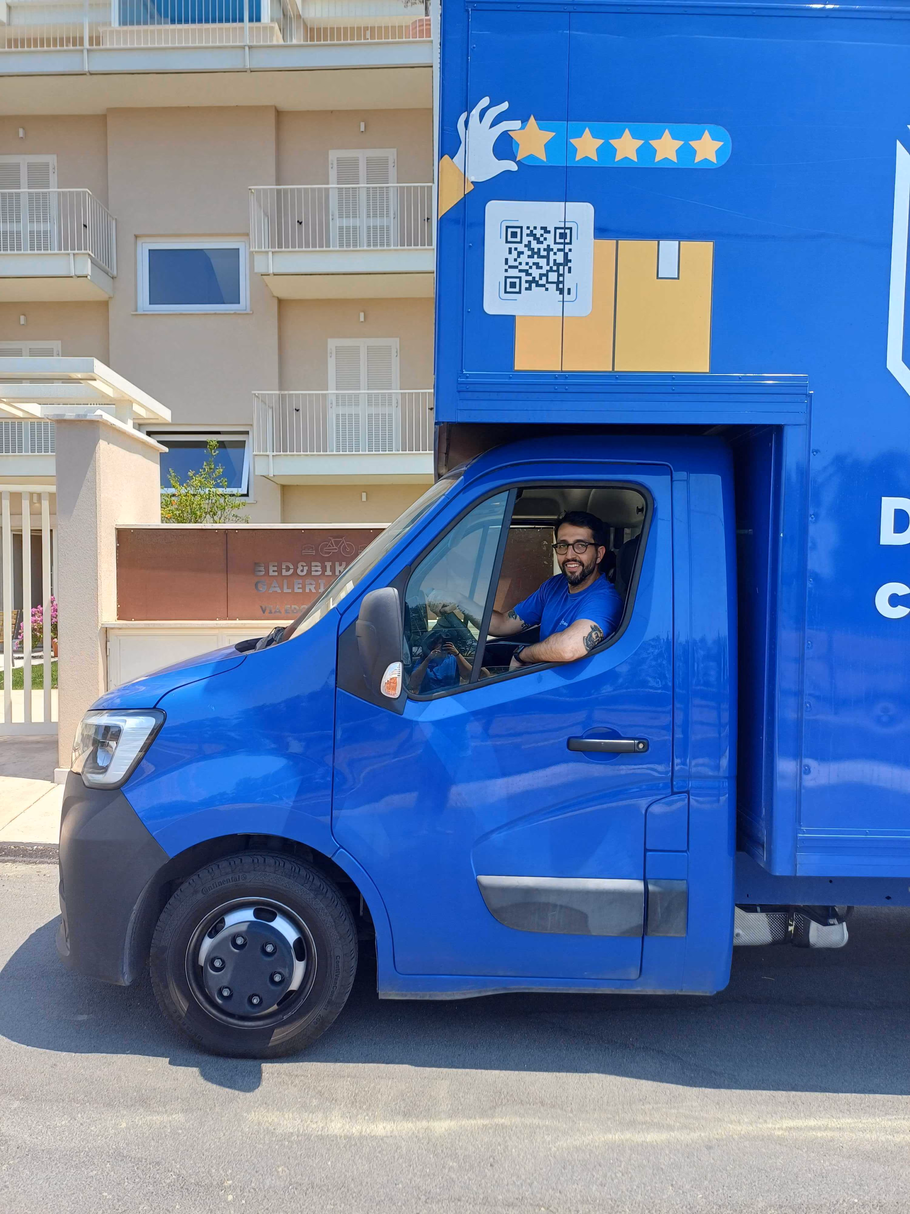 Addetto ai traslochi guida un furgone per il servizio di trasloco con deposito