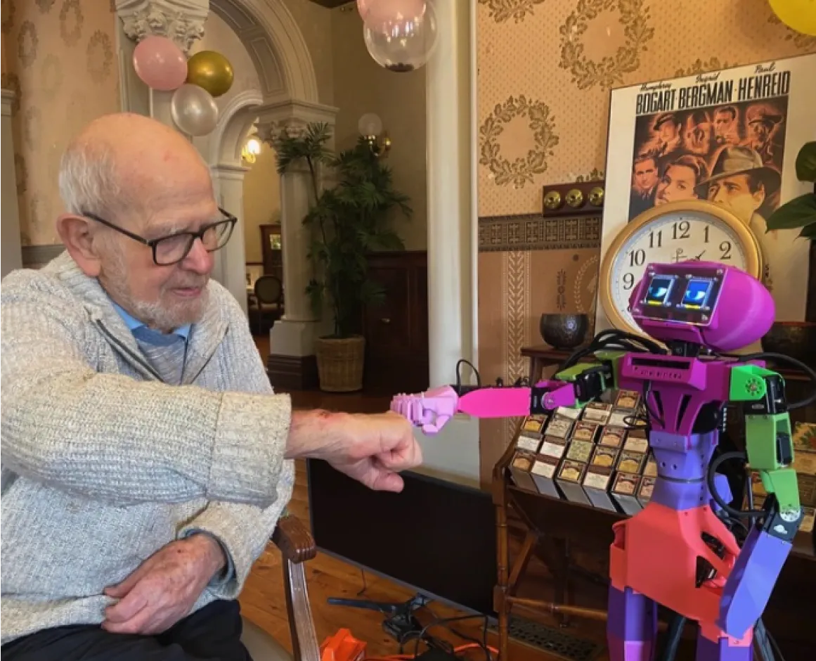 Abi the companion robot fits-bumps an elderly aged care resident