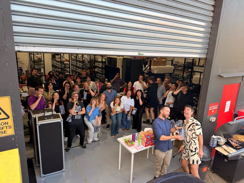 A warehouse full of Andromeda staff as Brian hands a gift to Dom