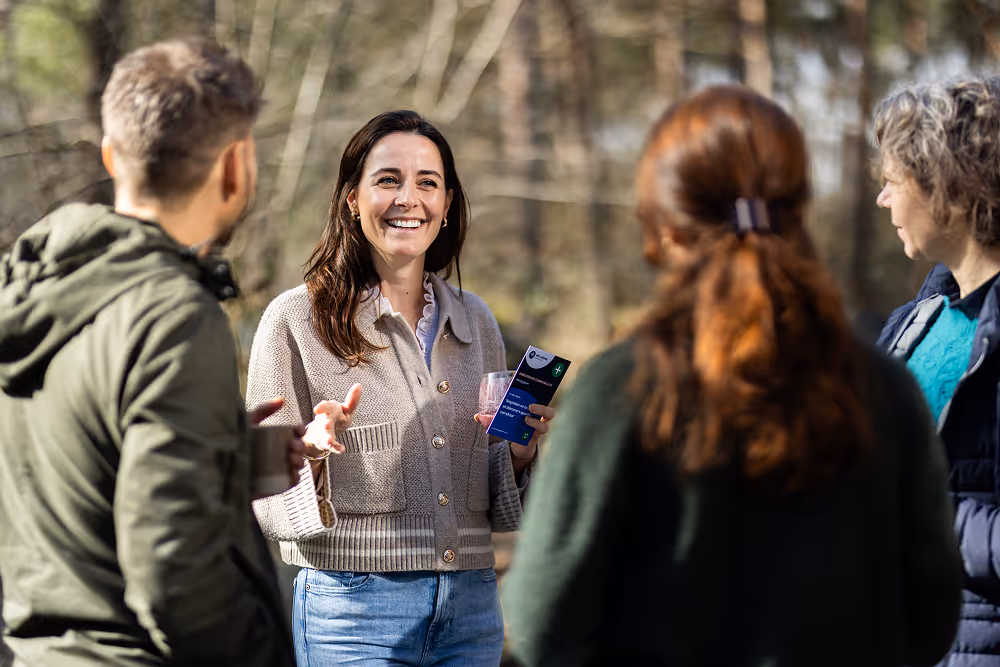 Een groep mensen discusserend in het bos