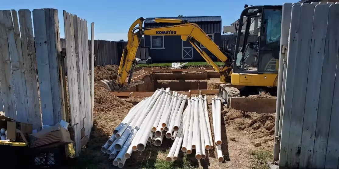  Photo of an excavator and pvc pipe on a construction site
