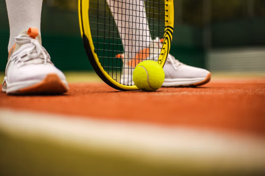 image of a tennis ball and player's racquet
