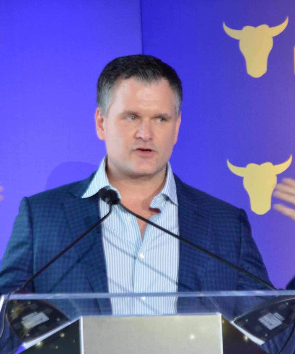 Daniel Roos speaking at a podium