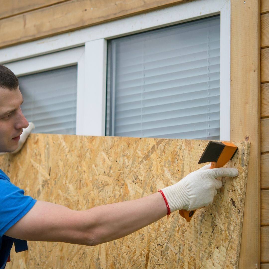 Man boarding up a window in Kingston upon Thames