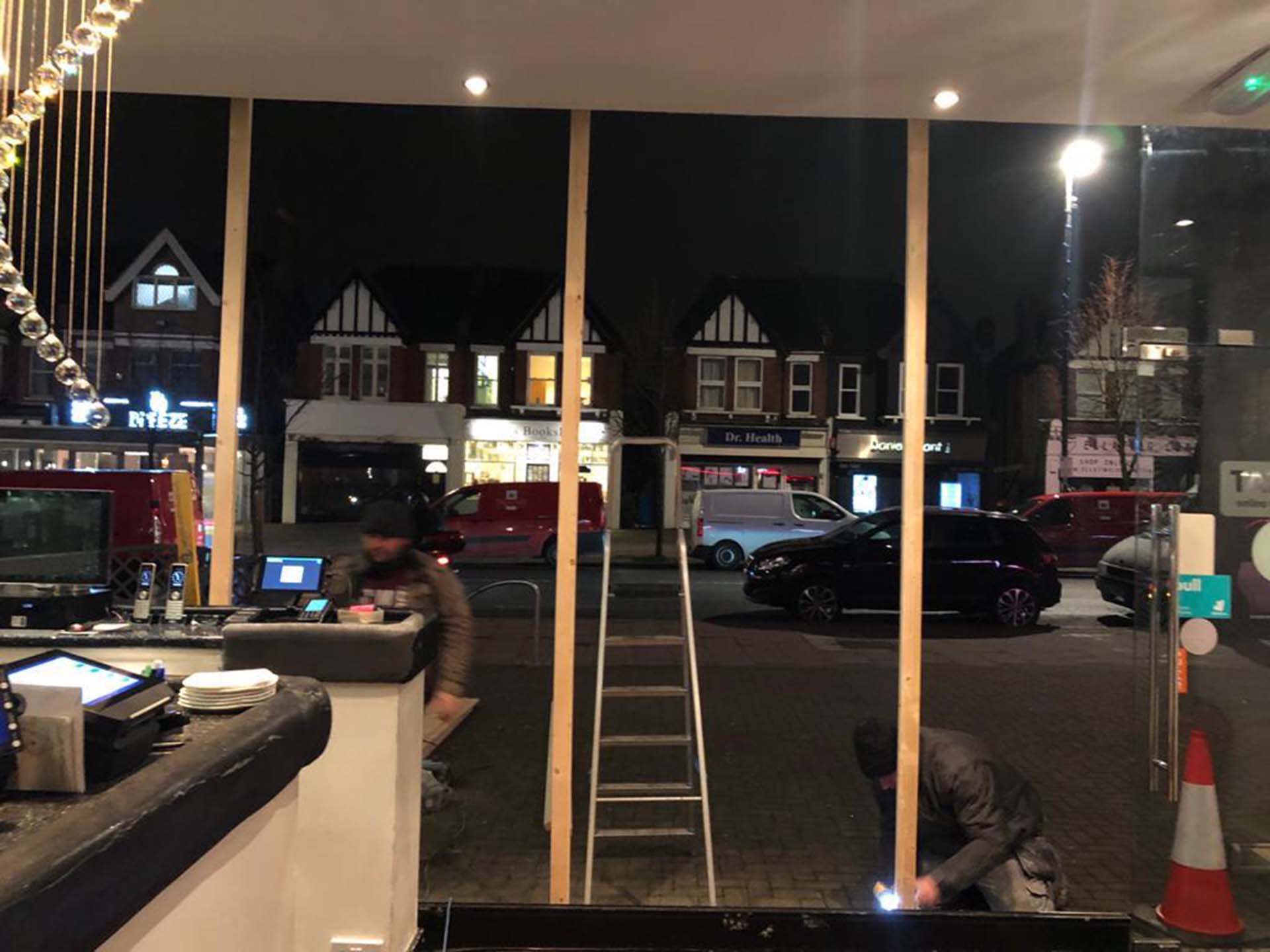 RLS South workers repairing cafe display window.