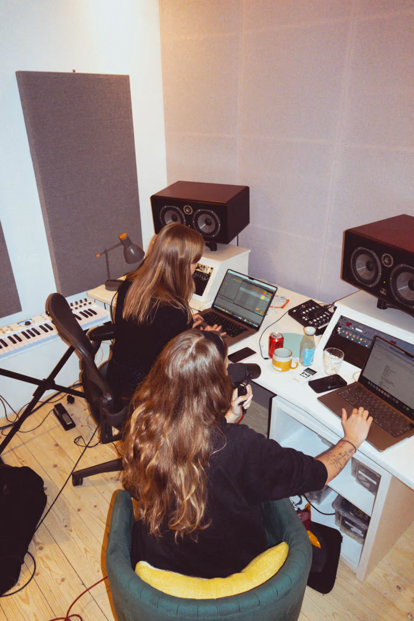 Two producers working at a studio desk with keyboard and monitors at Noatune Studios, East London
