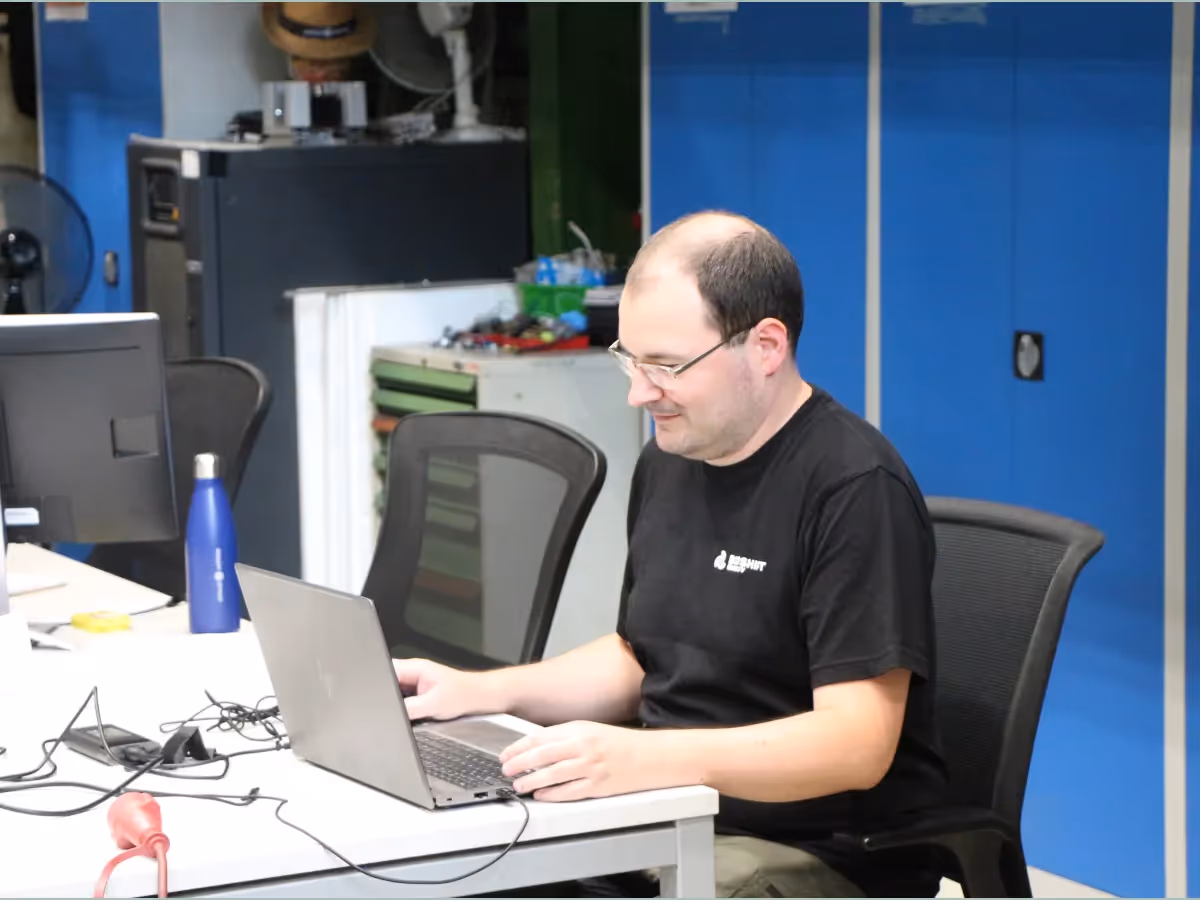 person sitting at a desktop working on a laptop