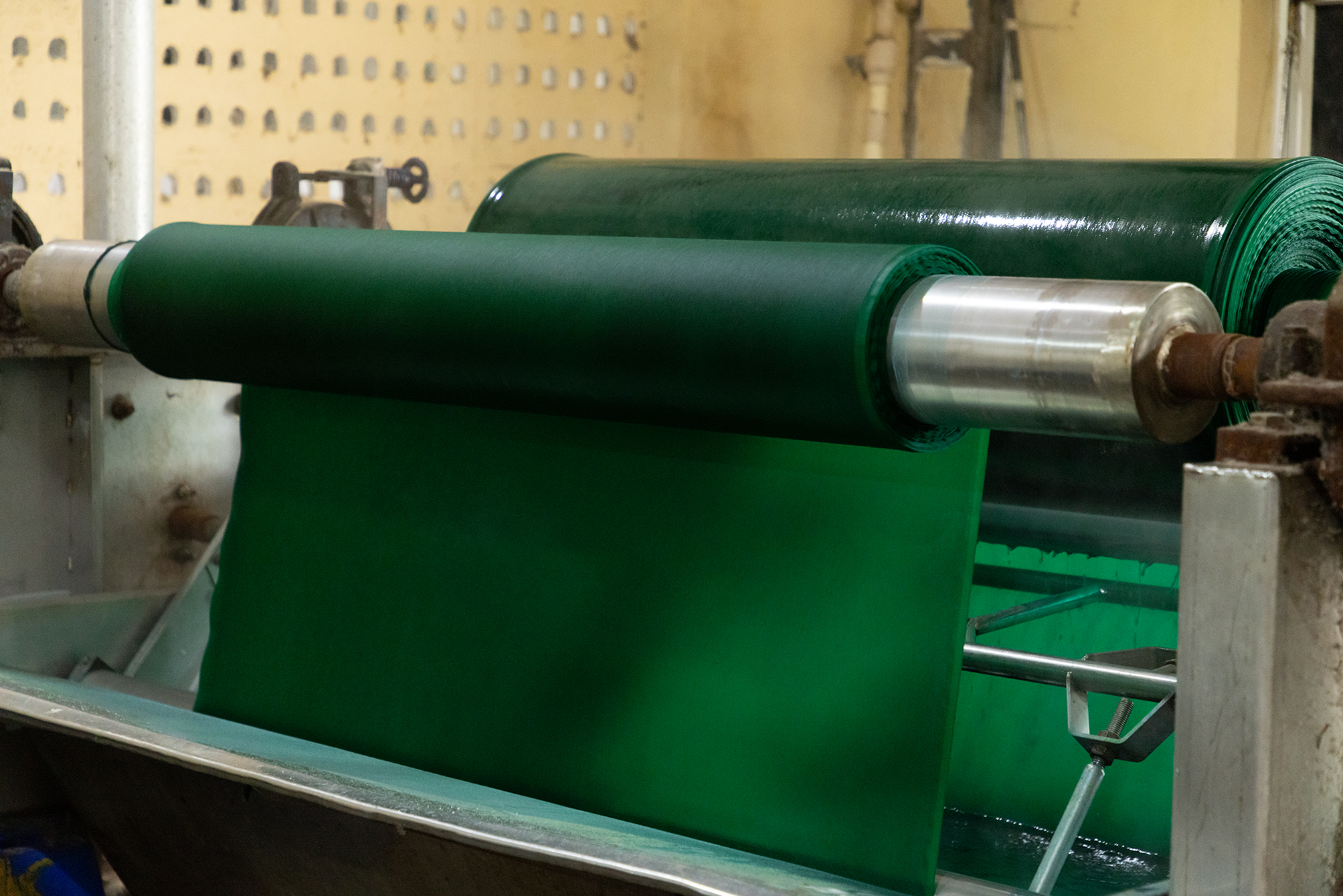 Cotton woven fabric in solid green color for garment manufacturing, processed at Anubav Fibres, Karur