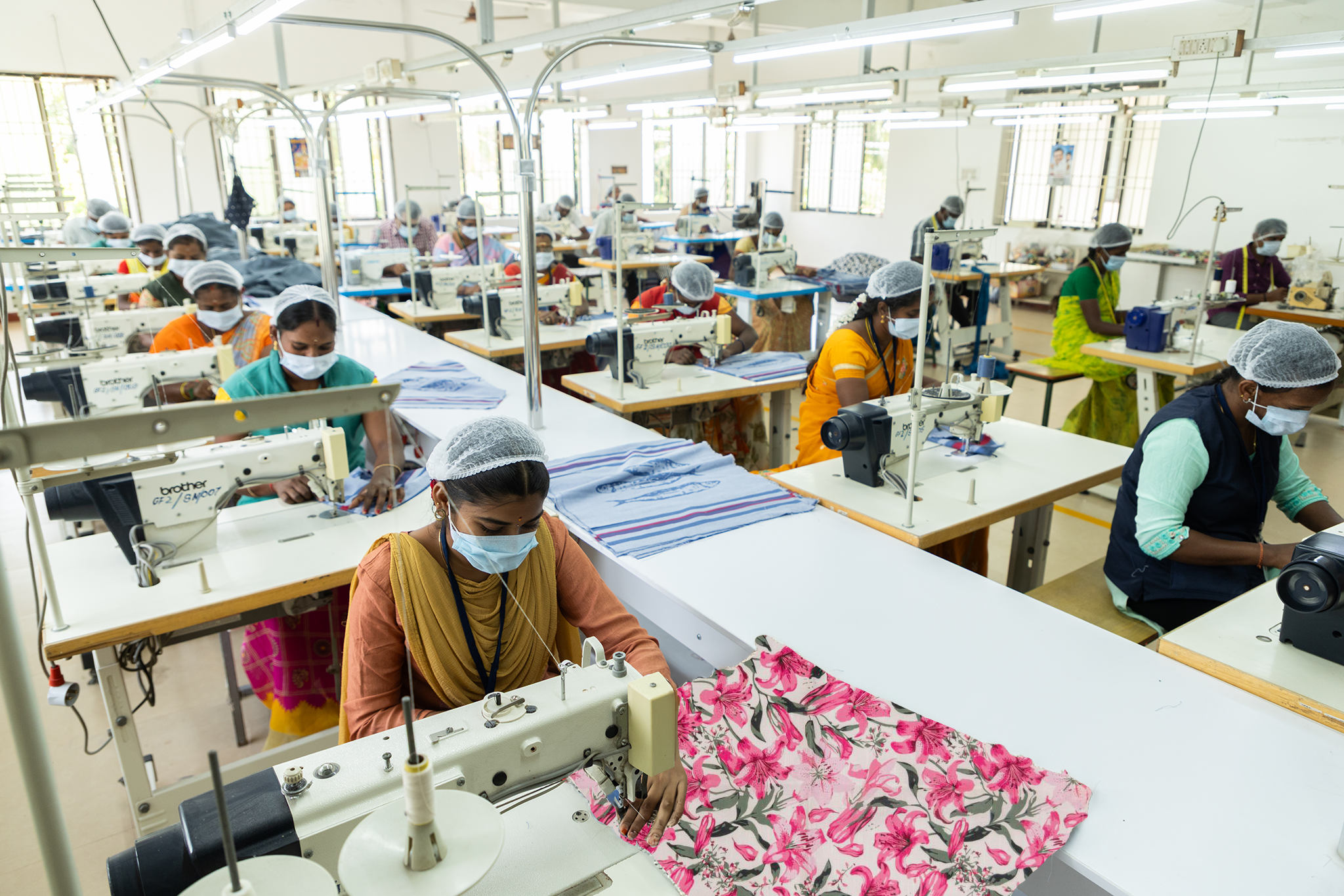 Stitched textile products made from cotton fabric in assorted solid colors are produced for home textiles and garment finishing through skilled sewing operations at Anubav Fabrics, Karur.