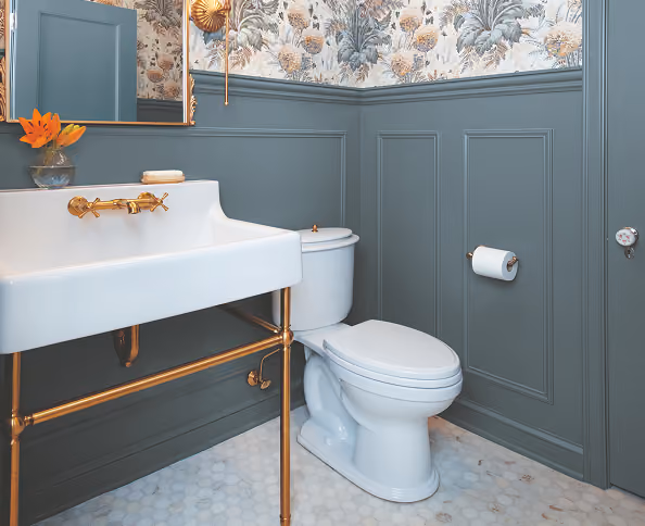 Bathroom with white fixtures and walls decorated with blue-gray wood paneling