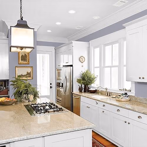 Bright kitchen with white cabinets, granite countertops, and gray-lavender walls