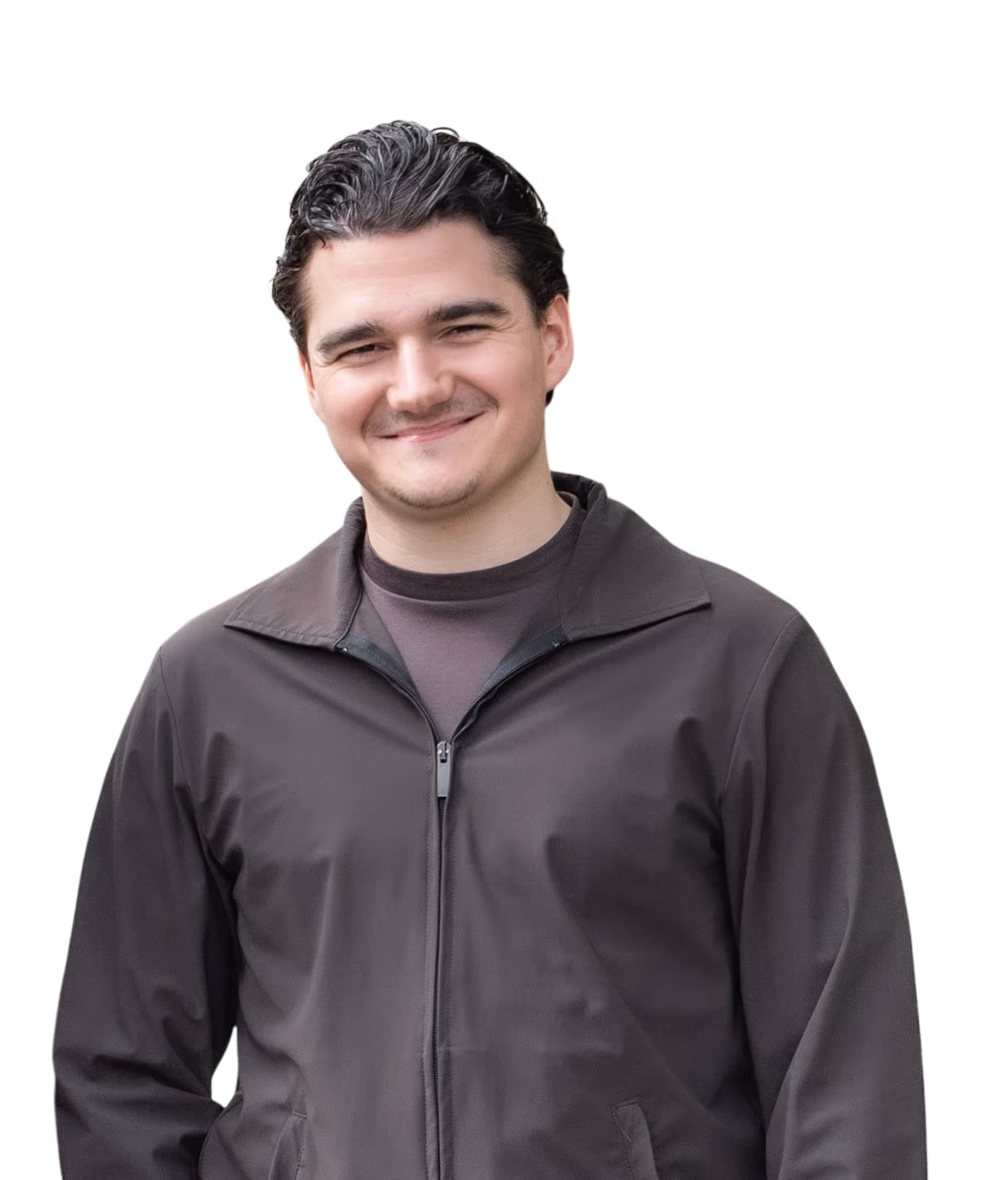 Smiling young man with dark hair wearing a zipped-up dark jacket and a dark t-shirt.