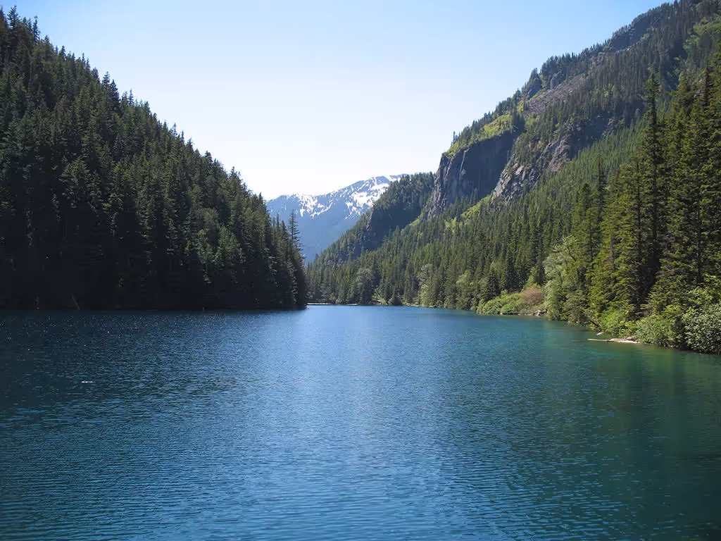 Turquoise waters of Lindeman Lake surrounded by rocky mountains in Chilliwack