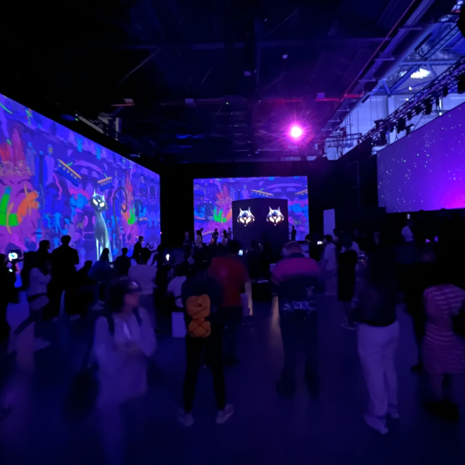Nephel’s Dream immersive exhibition, with visitors surrounded by colourful imagery on multiple large screens.