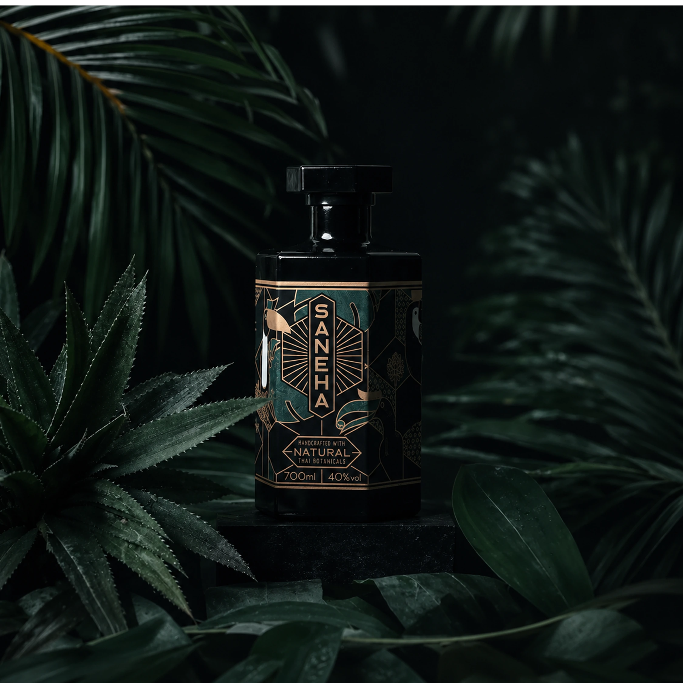 A dark bottle with a patterned label surrounded by tropical green foliage.