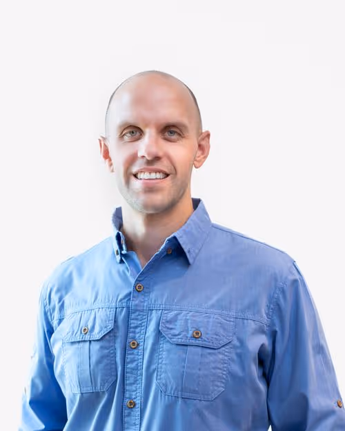 Professional headshot of Adam Jason, a man with short dark hair, smiling in a suit and tie.