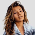Young woman with long brown hair wearing a striped blue and white sweater against a light background.