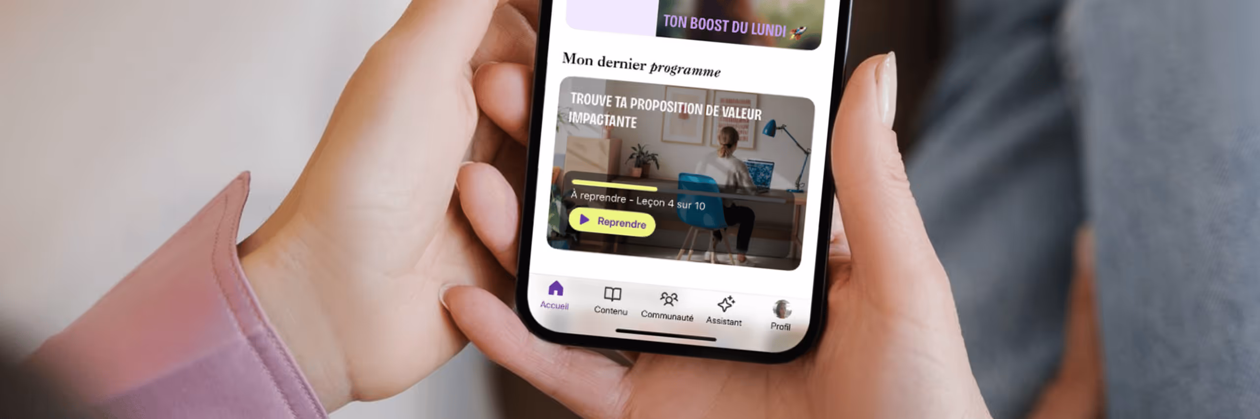 l'application les fondatrices dans un téléphone qui est tenu par une femme avec ses deux mains