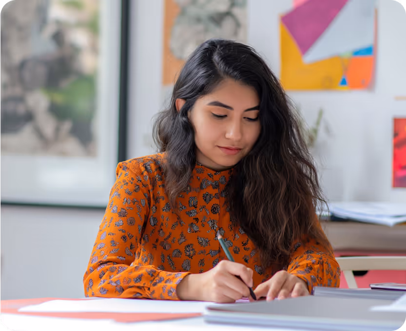 Femme écrivant à son bureau dans un environnement créatif et inspirant.