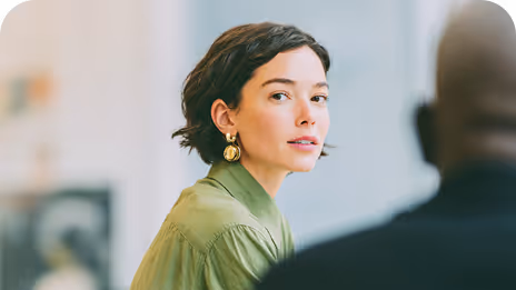 Femme attentive participant à une discussion dans un cadre professionnel.