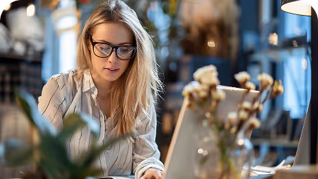 une femme en train de travailler devant un ordinateur