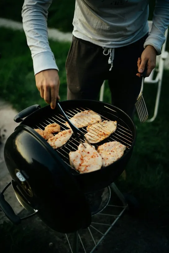 man barbecuing chicken
