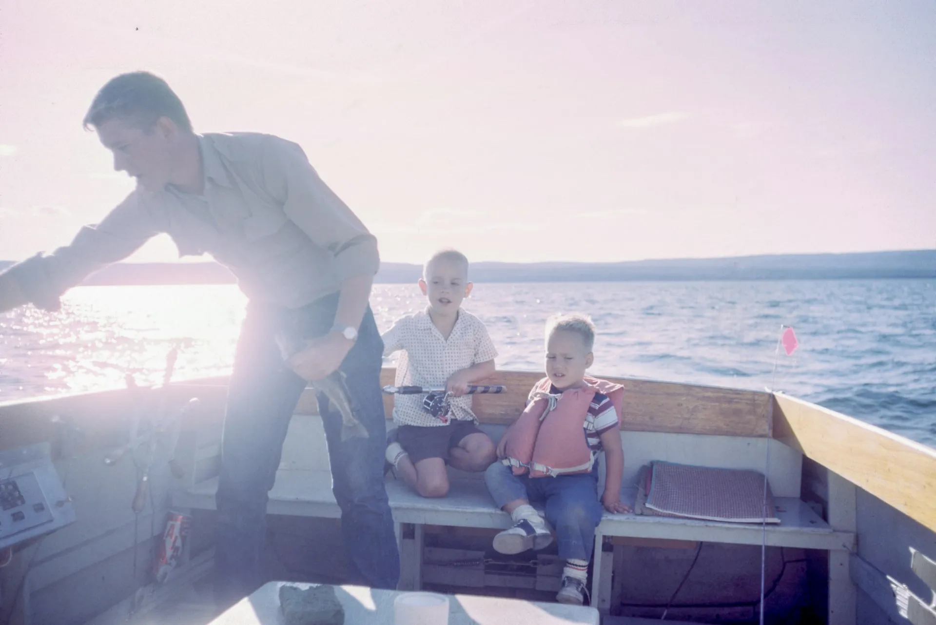 a dad and two kids on a boat