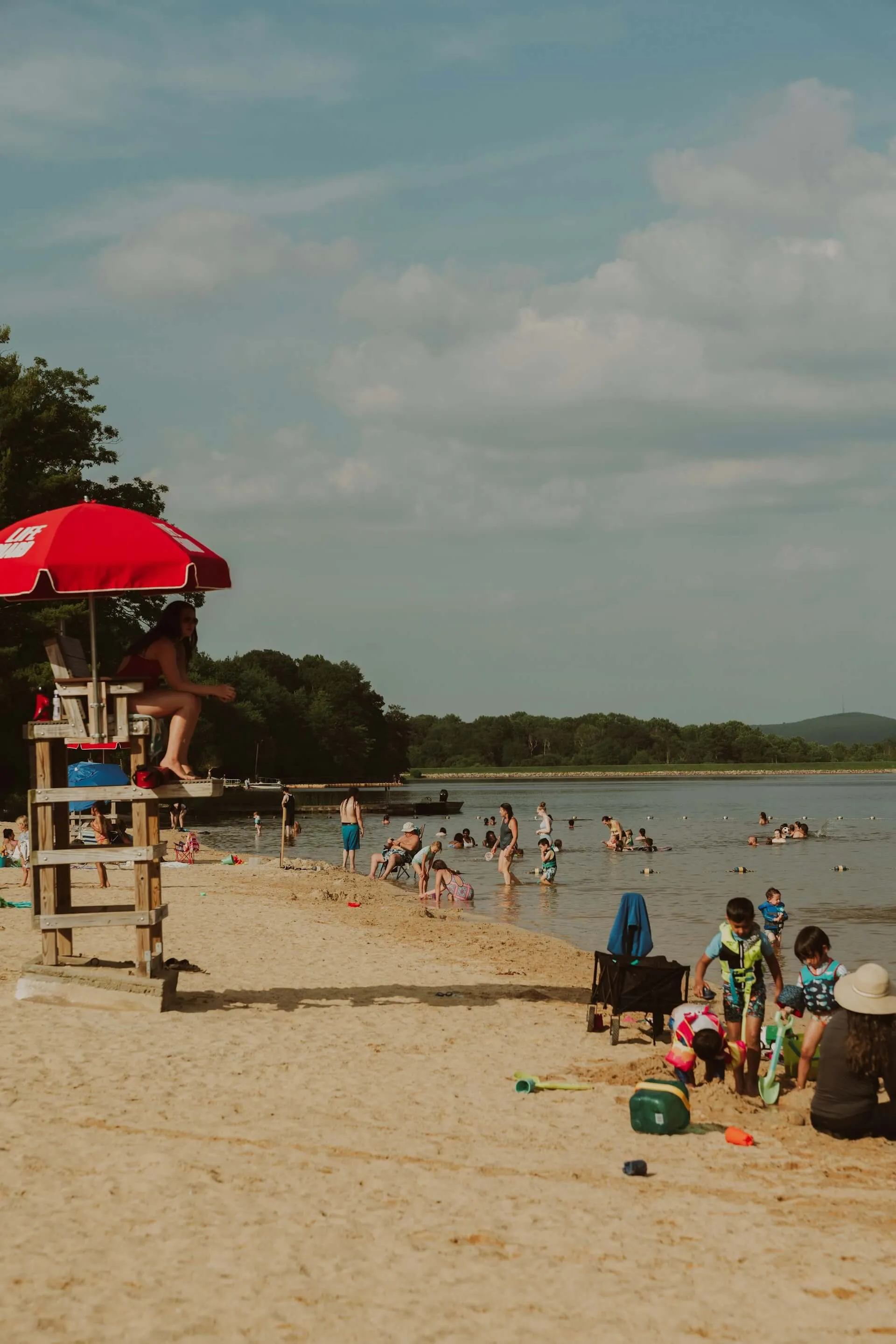 a lifeguard at the beach looking over people at a lake