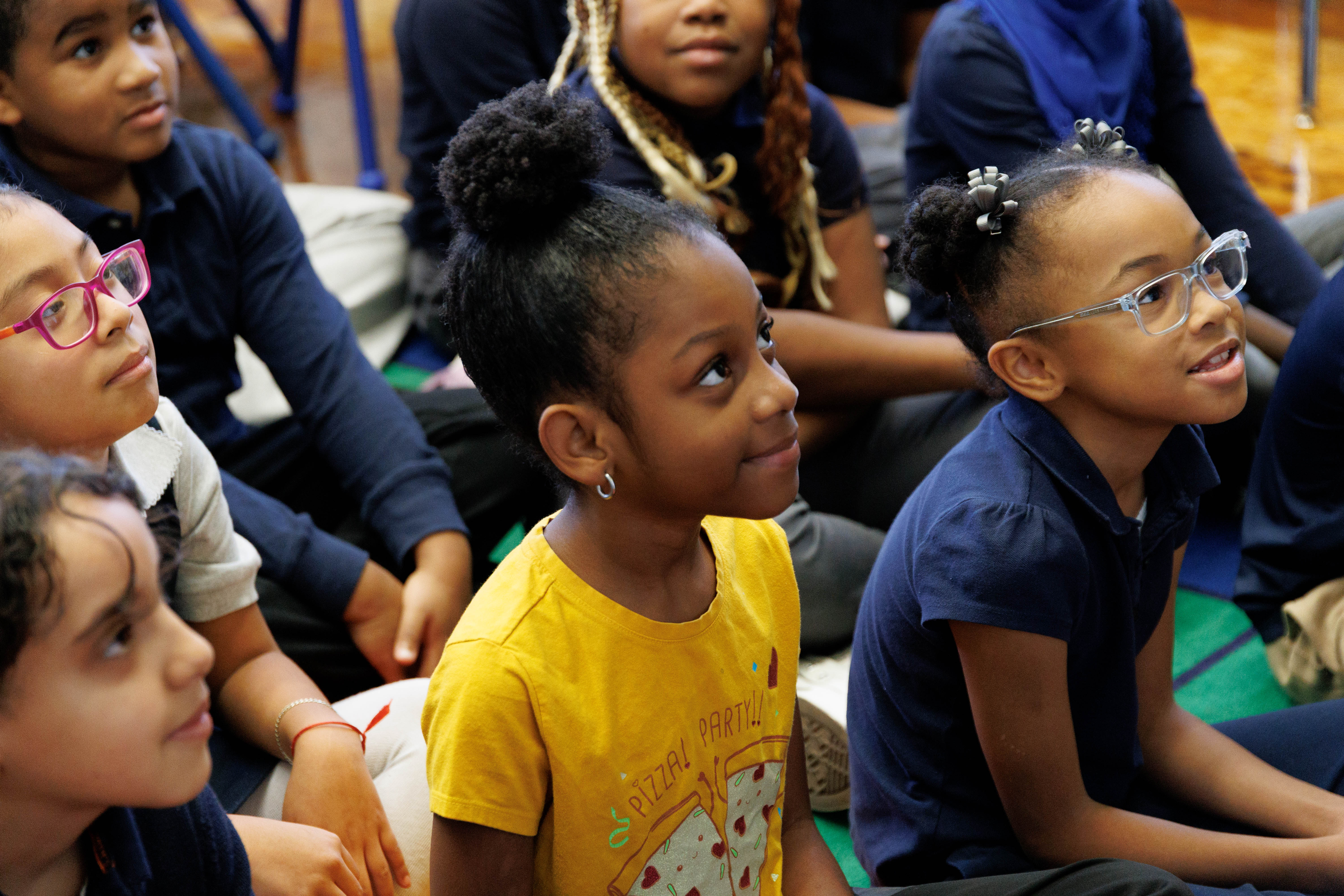 Students seated together attentively listening during a school assembly