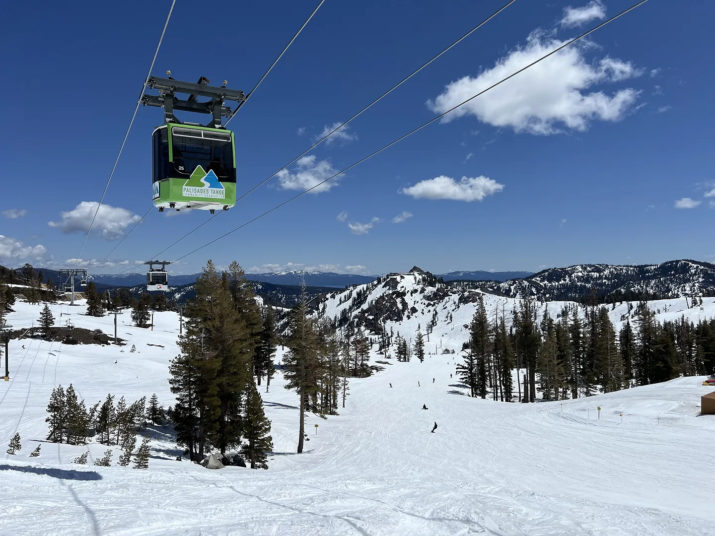 A laptop displaying a website about a private ski and golf community, featuring a background image of snow-covered mountains and ski lifts.