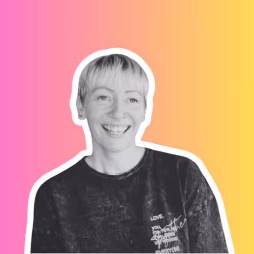 Smiling person with short blonde hair wearing a dark shirt against a pink to orange gradient background.