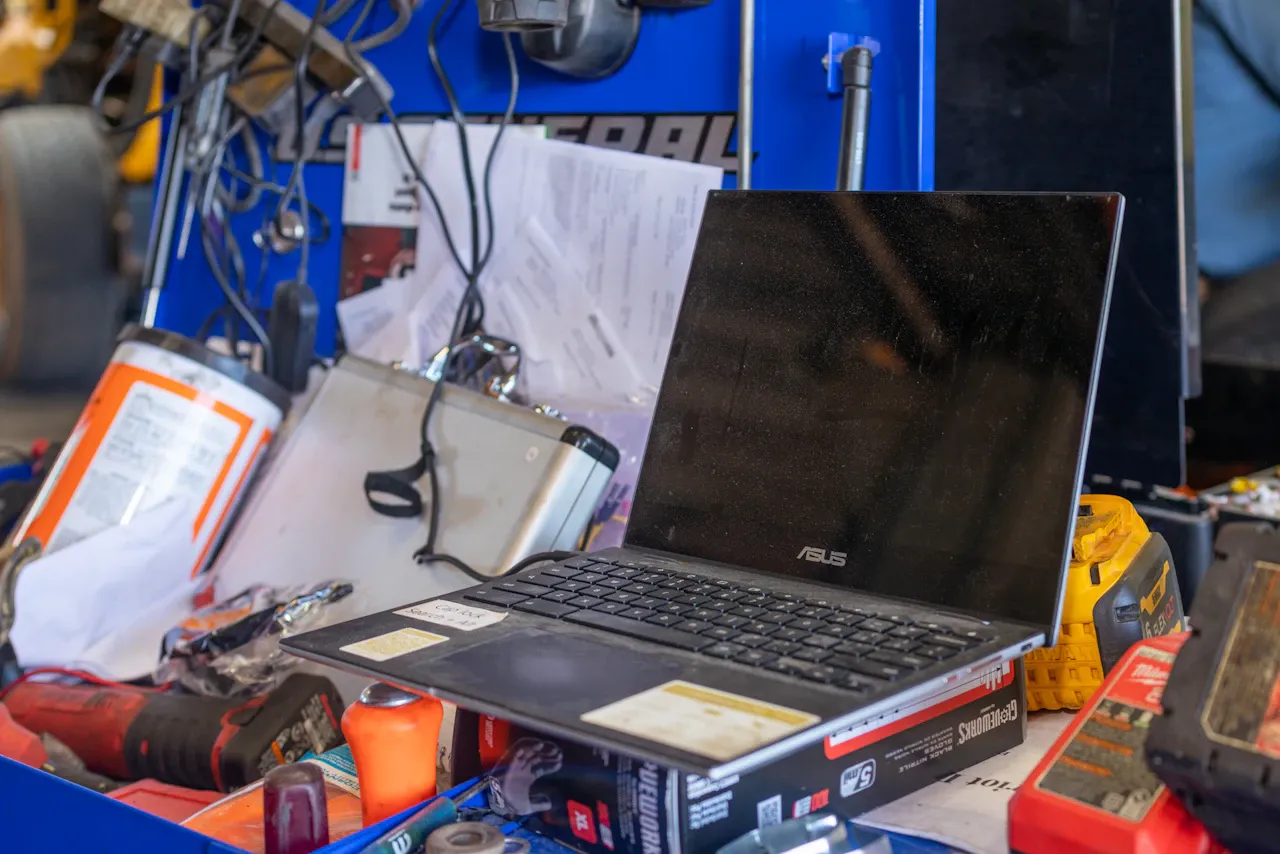 ECM tuning service showing diagnostic laptop and repair tools on workstation in heavy-duty truck repair shop.