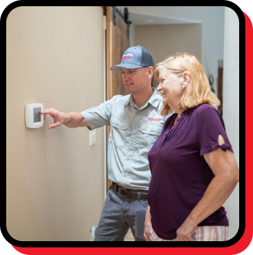 Technician demonstrating thermostat settings to a homeowner, emphasizing HVAC efficiency and smart thermostat services in Sisters, OR.