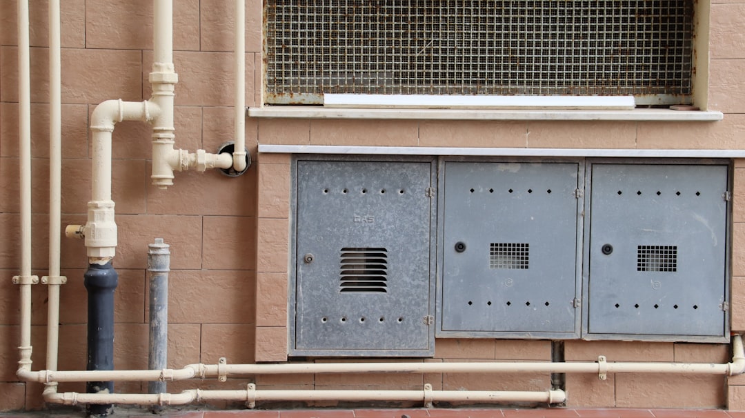 HVAC line set with copper piping and wiring running along an exterior wall - how the indoor and outdoor units are connected
