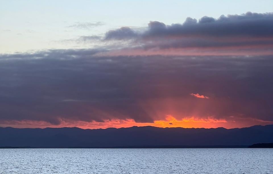 Atmospheric orange sunset and cloud cover over the ocean.