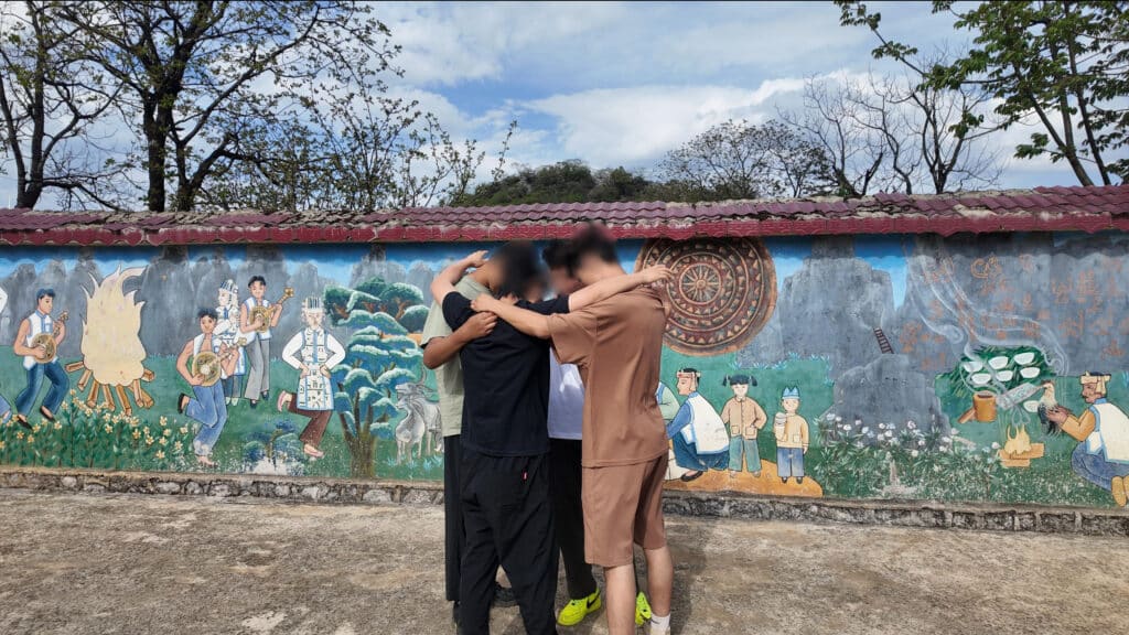 Team prayer walking in village, huddled together