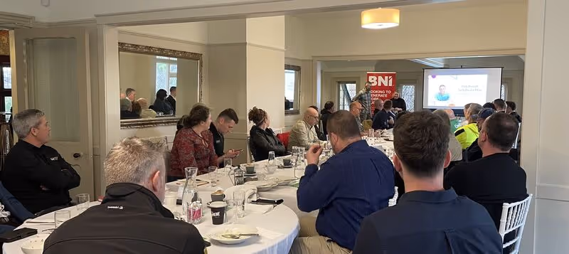 The BNI avenues team sitting around the table listening to a chapter members 10 minute presentation