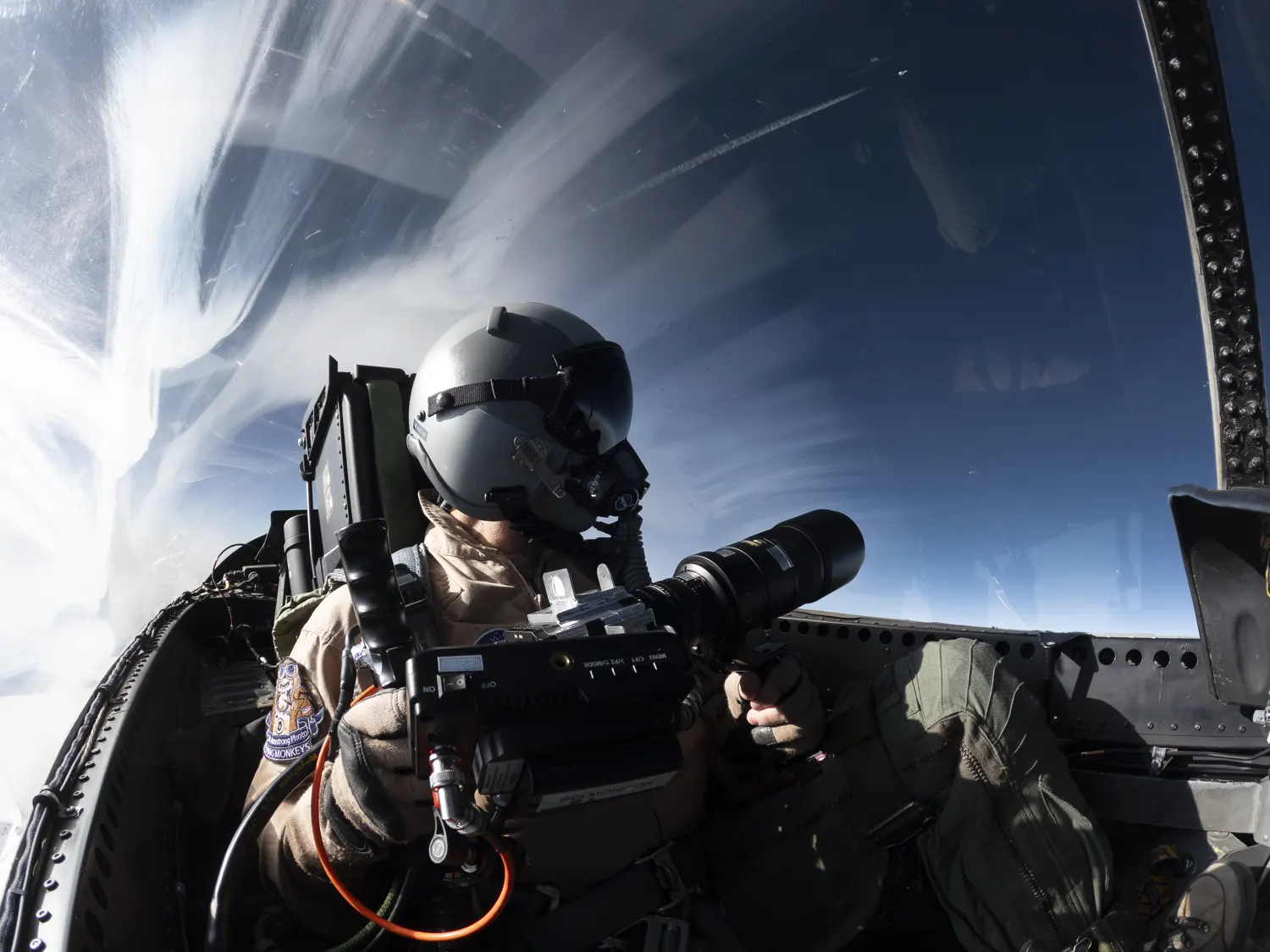 A NASA photographer captures schlieren imagery from the back seat of a research aircraft