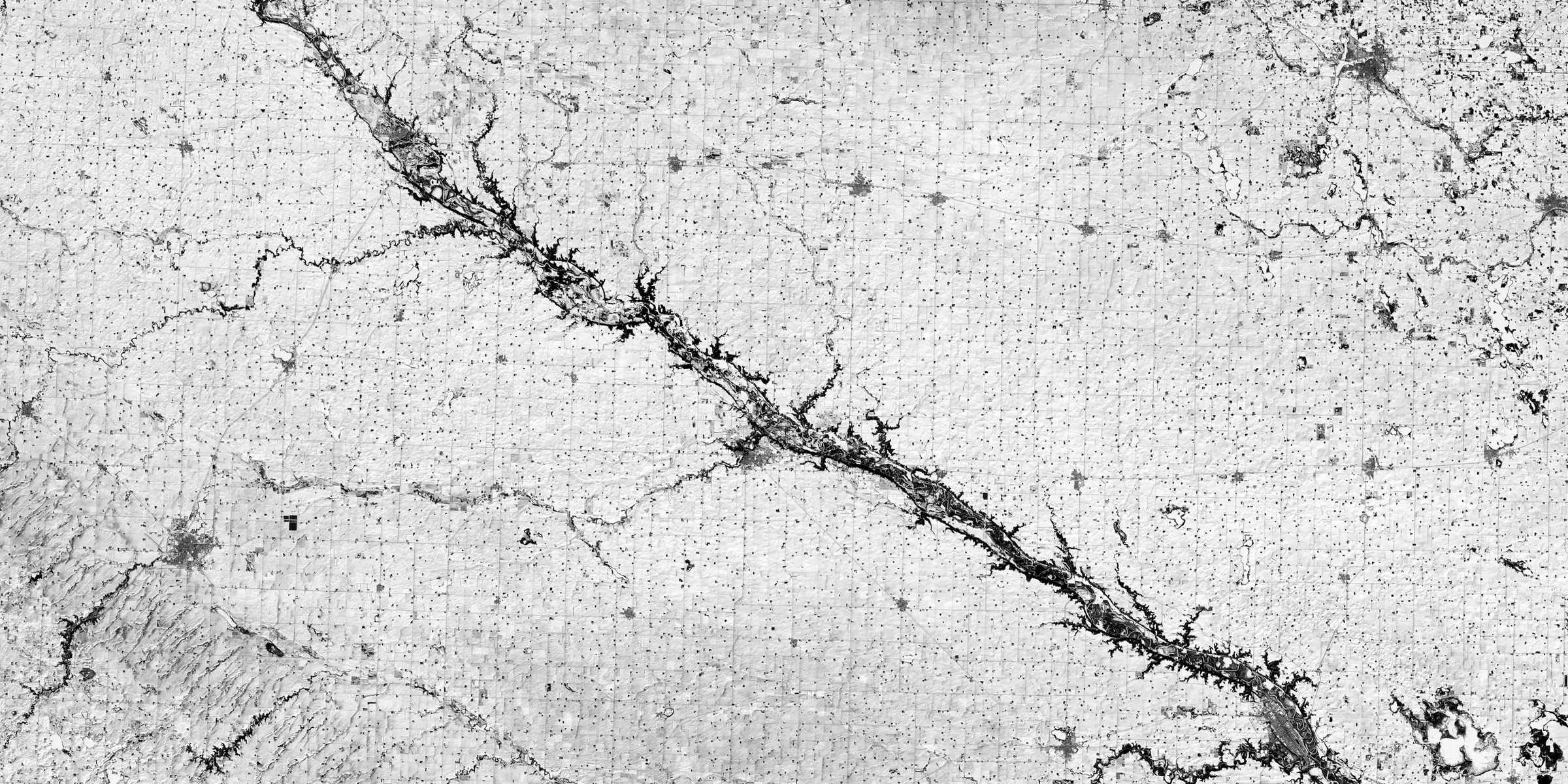 A single river runs through snow-covered farmland in southwestern Minnesota, seen from orbit