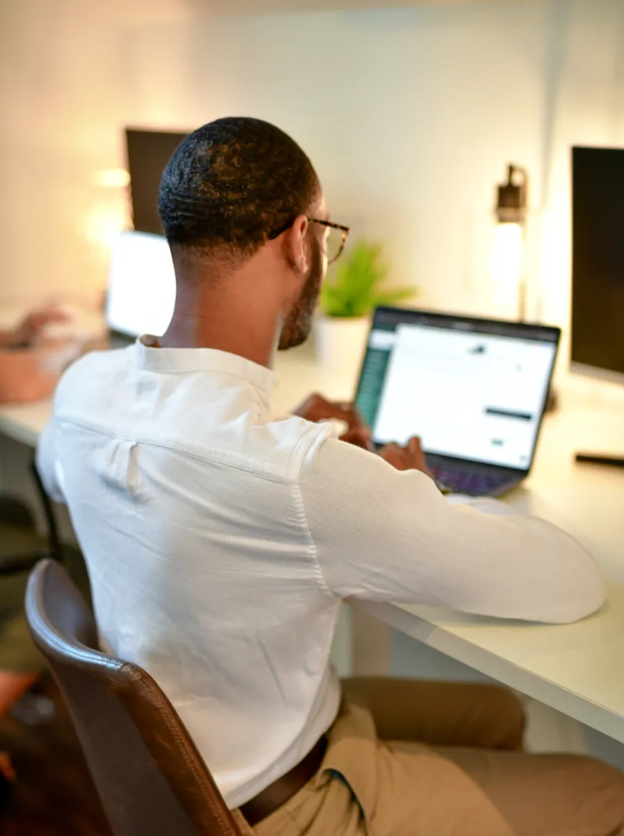 A man with glasses sits at his desk scheduling social media posts for law firms.